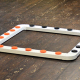 A white sniffer dog system with orange and black vented metal pots and connectors on a wooden floor.