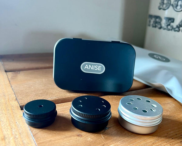 Anise product packaging with various containers on a wooden surface