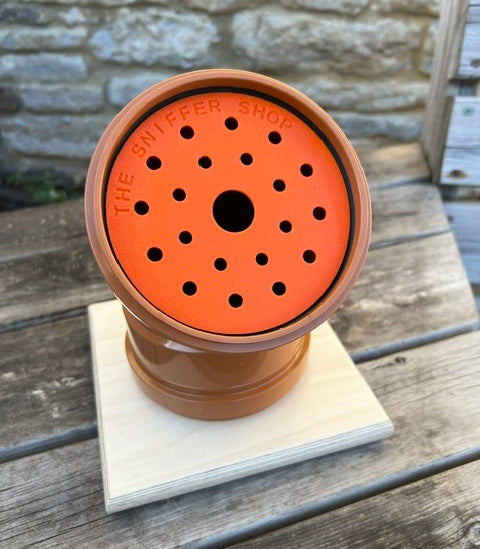 Oranve scentwork cover on a brown pipe